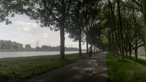 Frau-Radfahren-Auf-Der-Straße-In-Einer-Typischen-Holländischen-Dorflandschaft