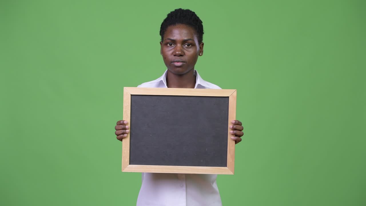 Young beautiful African businesswoman holding blackboard