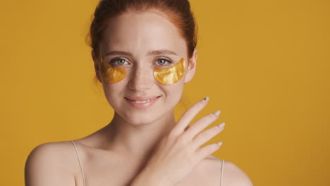 redheaded girl in front of camera on yellow background.