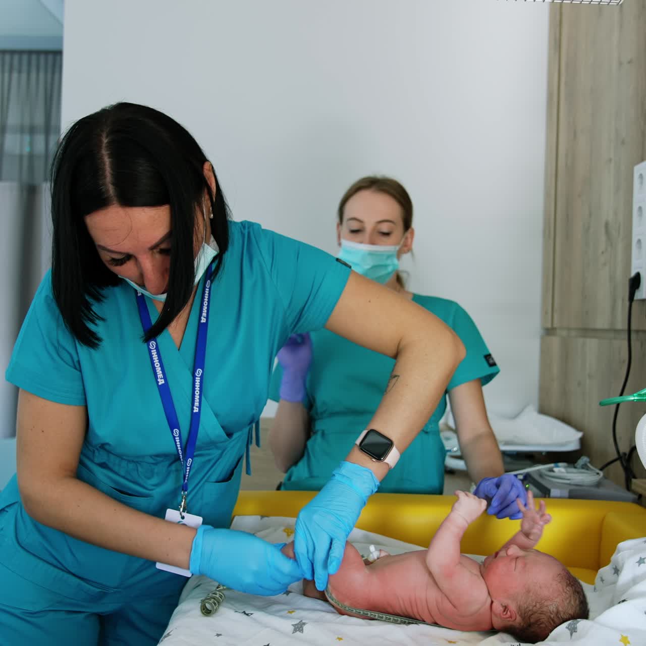 Doctor puts the measuring tape to a little newborn baby's back. Assessing the child's growth and development in the hospital