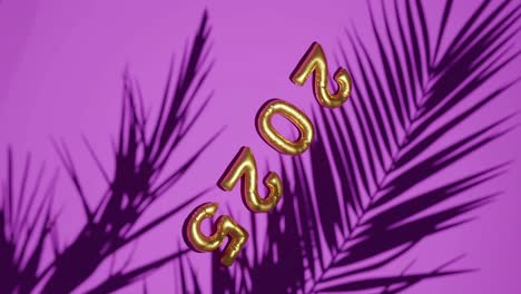 golden ballon 2025 on silhouetted palms pink background vertical