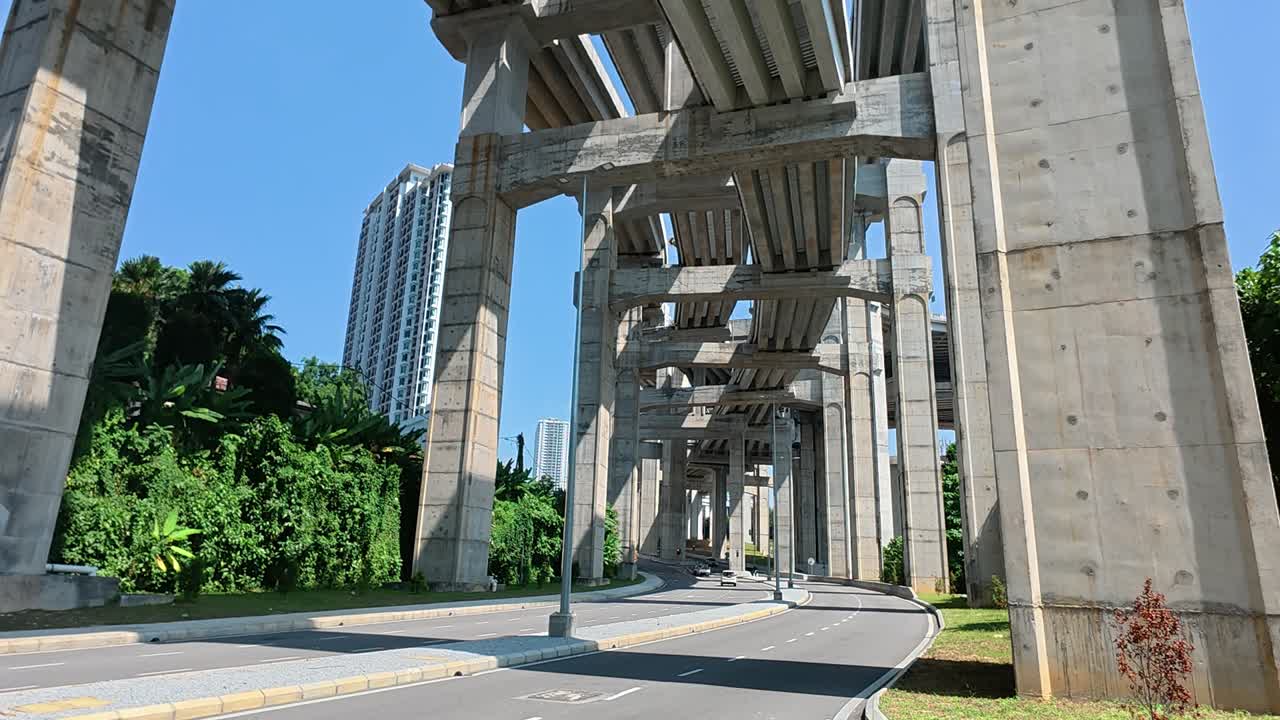 A low-angle view of a high elevated road shows massive concrete pillars, beams, and portals. This engineering marvel is designed to disperse heavy ground traffic