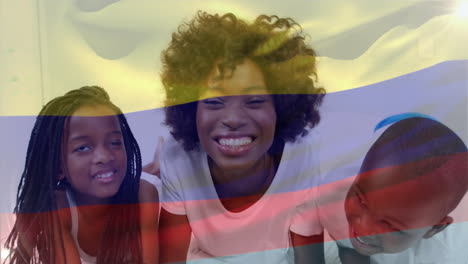 animation of flag of colombia over african american mother with children kissing