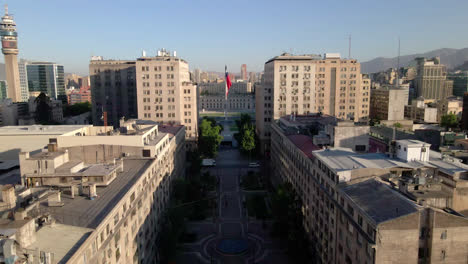 Paseo-Bulnes-front-of-presidential-palace-with-Chilean-Flag,-Santiago-de-Chile-aerial