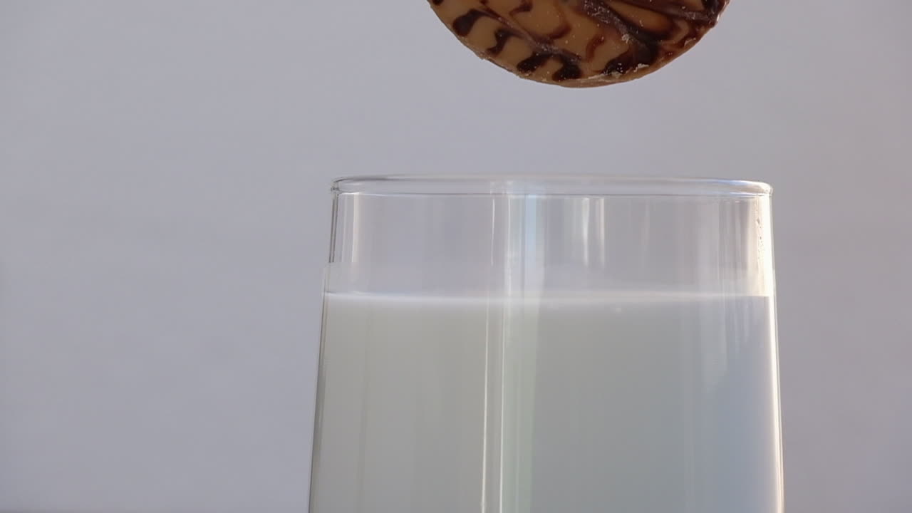 filmati al rallentatore di un biscotto digestivo al cioccolato che viene inzuppato in un bicchiere di latte