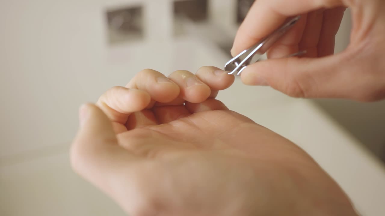 Person Cutting Fingernails With Nail Cutter. closeup