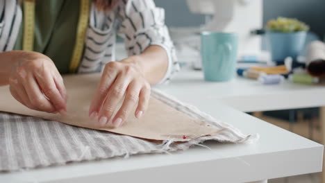 woman working on fabric and pattern in a sewing studio