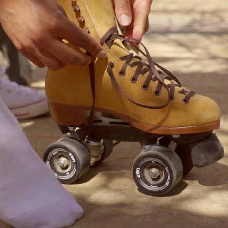 Young-woman-putting-on-roller-skates