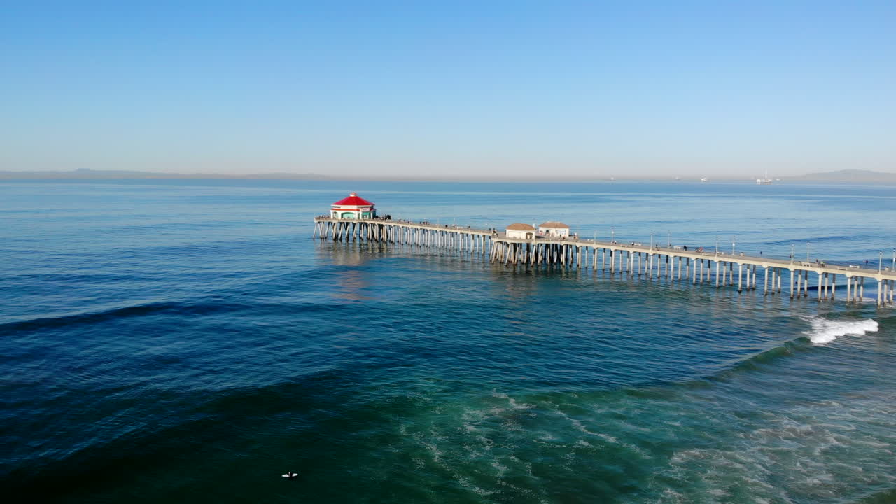 넓고 느린 공중 4k 드론이 식당이 보이는 헌팅턴 비치 부두로 이동, 태평양, 캘리포니아, 아침, 햇살