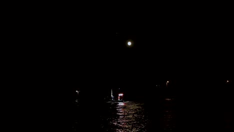Kleines-Beleuchtetes-Boot-In-Einem-Meer-Bei-Muschelbauernhütten