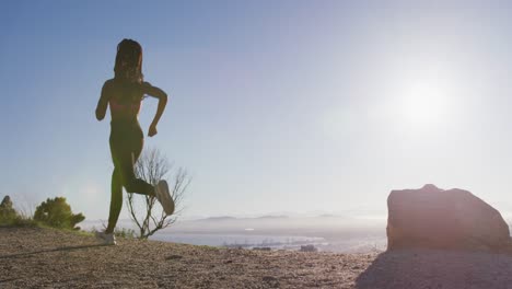 African-american-woman-wearing-face-mask-running-outdoors