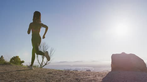 african american woman wearing face mask running outdoors