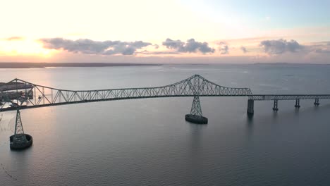 Silhouetted-Astoria-Megler-Bridge-In-Astoria,-Oregon,-USA,-drone-flight-at-sunset