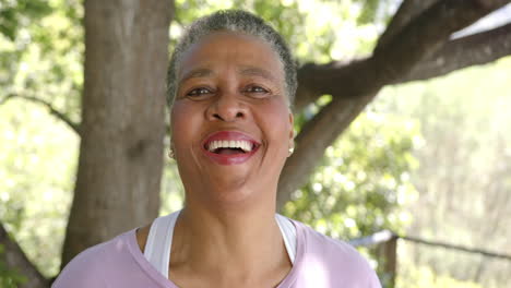 Portrait-of-happy-senior-african-american-woman-smiling-in-sunny-nature,-slow-motion