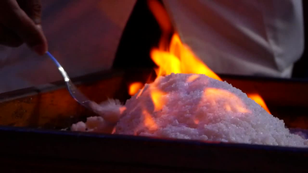 Live cooking in a restaurant on lanzarote, burning a fish, covered in salt.