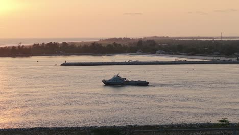 un barco navegando a través de un canal hacia el océano atlántico al atardecer en lagos, nigeria