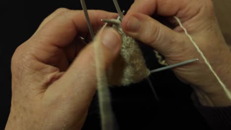 abuela hábilmente tejer con lanzas tradicionales, artesanía con lana de oveja natural, arte atemporal de primer plano