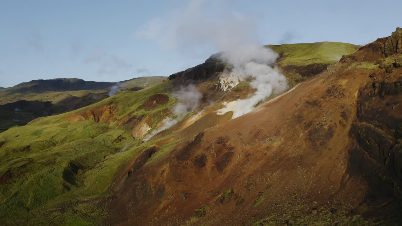 vapor que sale de las colinas en islandia mostrando el poder geotérmico de la tierra