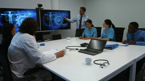 senior doctor giving presentation to team of interim doctors