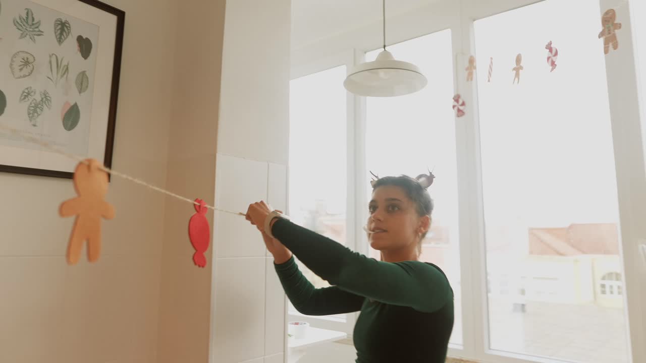Woman Decorating Kitchen with Christmas Garland
