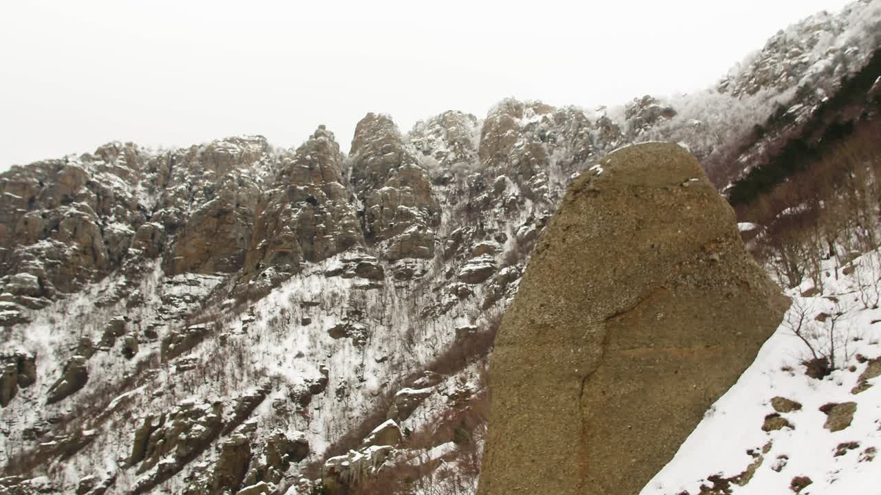 снежный горный ландшафт с крупными скальными образованиями