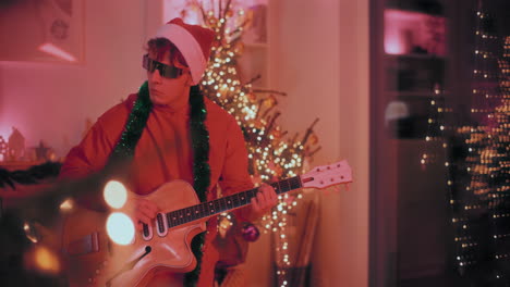 man playing guitar at home during christmas