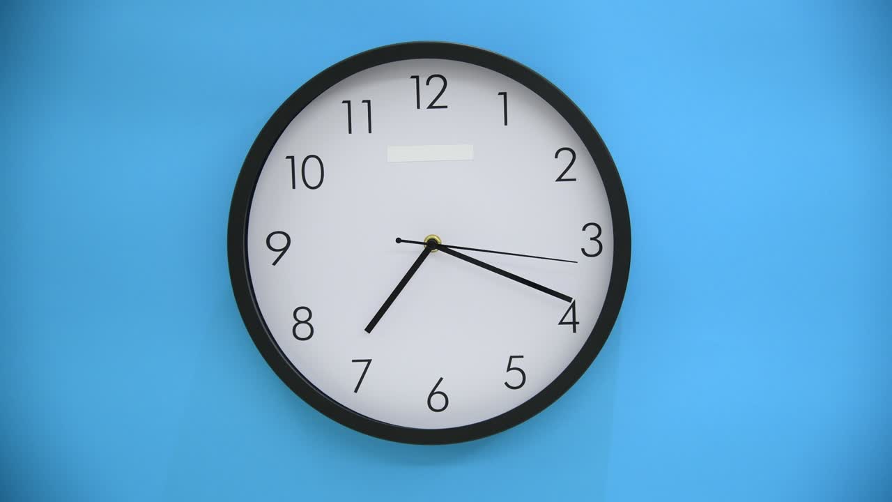 Orologio da parete bianco su sfondo blu.