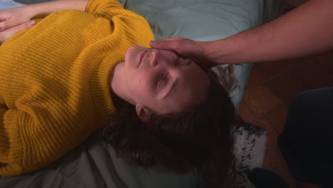 la mano de un hombre toca el rostro de la mujer acostada - de cerca