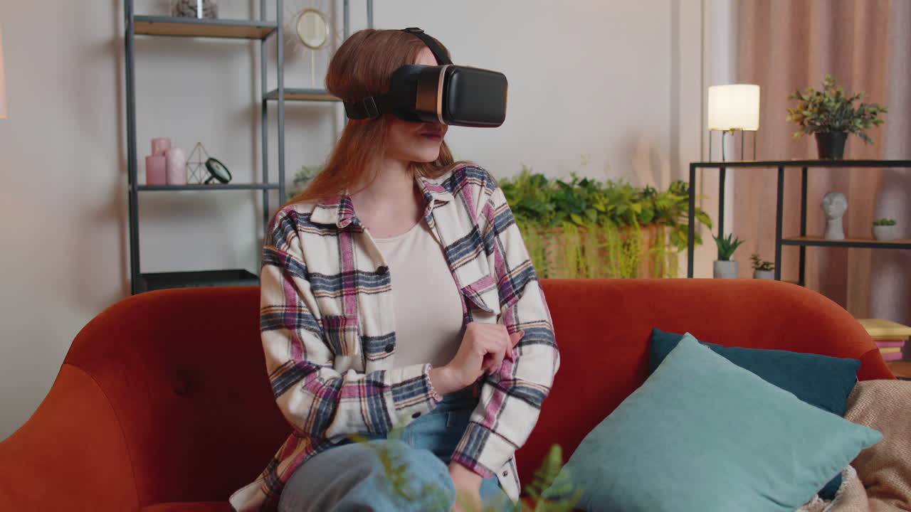 niña joven usa gafas de realidad virtual en casa juega videojuegos en 3d haciendo gestos con las manos