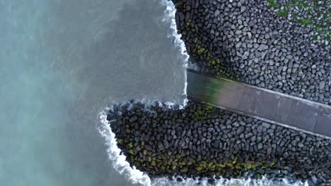 Aerial-footage-circling-above-concrete-slipway-and-breakwater-on-Hendon-Beach---Sunderland,-UK