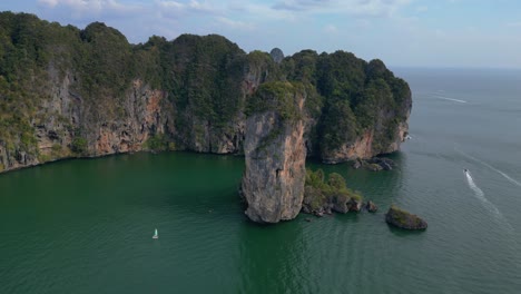 Breathtaking-view-of-a-secluded-bay-with-turquoise-water,-surrounded-by-towering-cliffs-covered-in-lush-green-vegetation