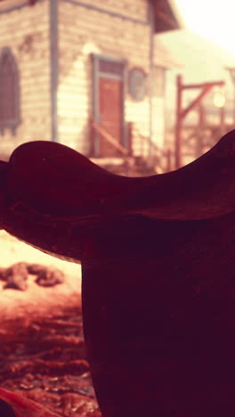 close-up of a leather saddle in front of a western building