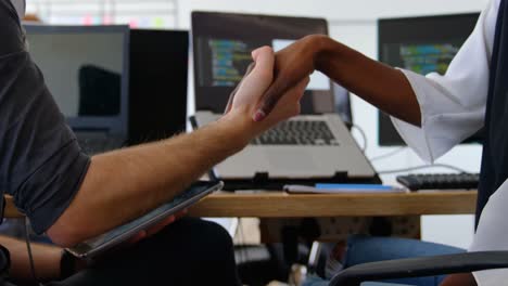 Mid-section-mixed-race-business-team-shaking-hands-on-business-deal-in-a-modern-office-4k