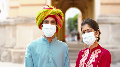 close-up of indian couple wearing surgical masks outdoors