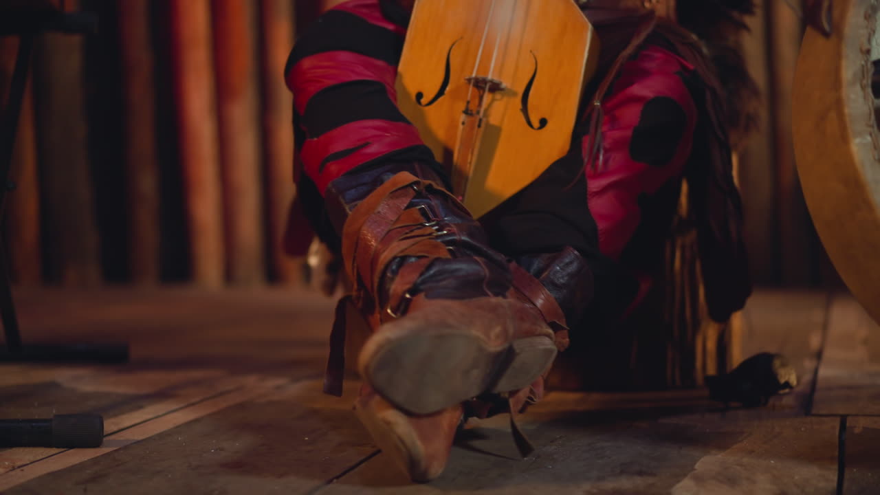 Stivali di un musicista che si prepara a suonare l'igil con l'archetto a un concerto