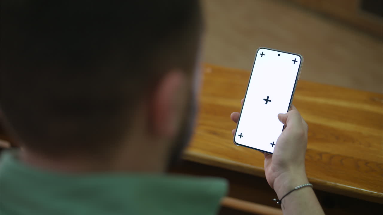 Hands of a man scrolling on a phone with white screen and tracking points, chroma key ready.