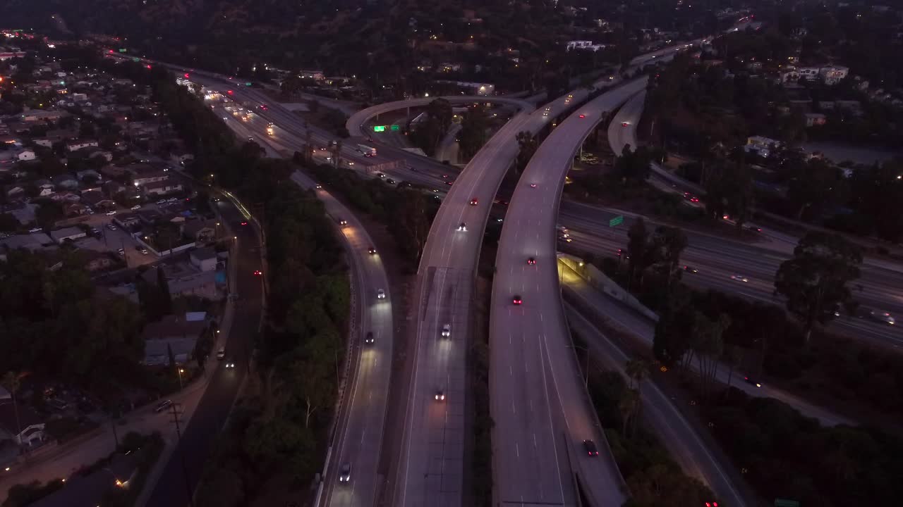 vista aérea coches que conducen por la autopista en el cruce por la noche con faros