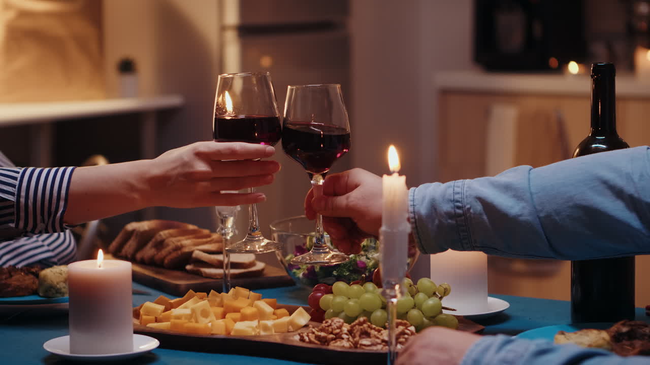 Vetri di vino tintinnanti delle giovani coppie