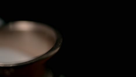 detailed close-up of wedding rings with rich textures against a dark background. the lighting highlights the metal, creating a romantic, intimate mood in this macro shot