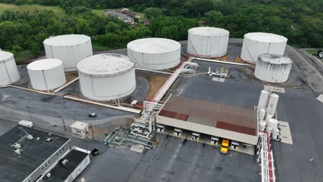 yellow truck parking at loading ramp for petroleum in american town. aerial top down. several tanks with field for aircraft
