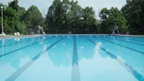 tilt to reveal a deserted outdoor olympic size swimming pool