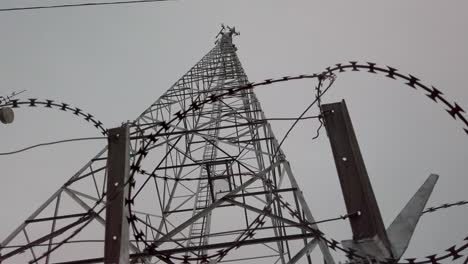 alambre de púas de ángulo bajo mirando hacia las torres de telefonía móvil