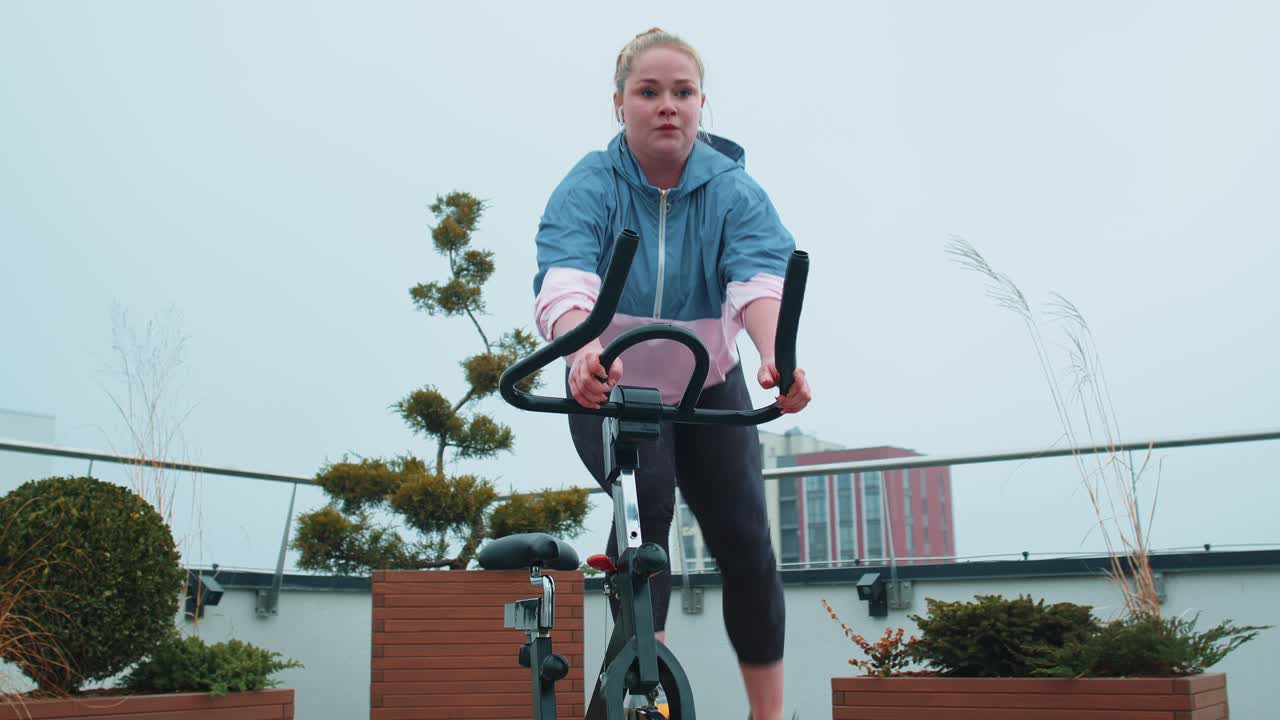 Woman performs aerobic endurance training workout cardio routine on the simulators cycle training