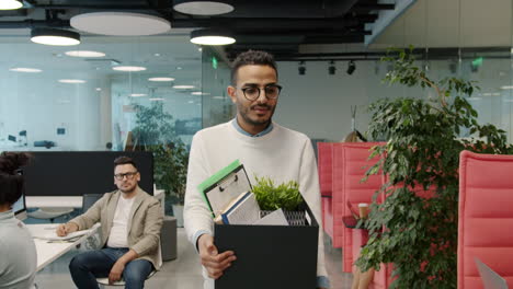 employee leaving the office with a box of belongings