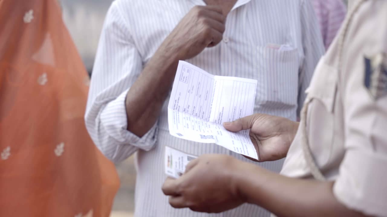 Police personnel checking and verifying voter id card of voter during Bihar assembly election