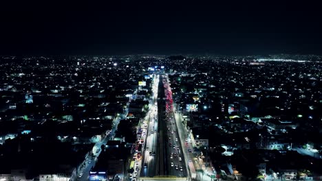 flying over main highway in mexico city at night time, residential area view