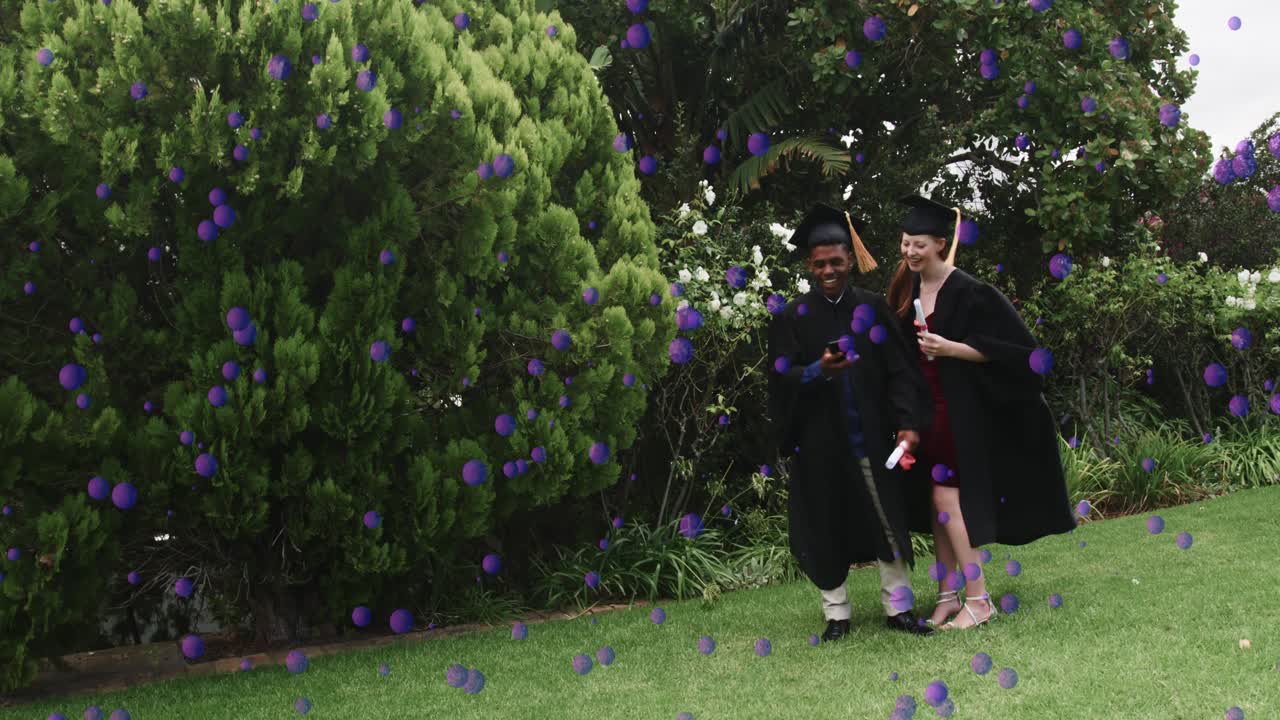 Due laureati che entrano da destra, a braccetto, sollevando il telefono, sovrapposizione di coriandoli di laurea che cadono sul prato