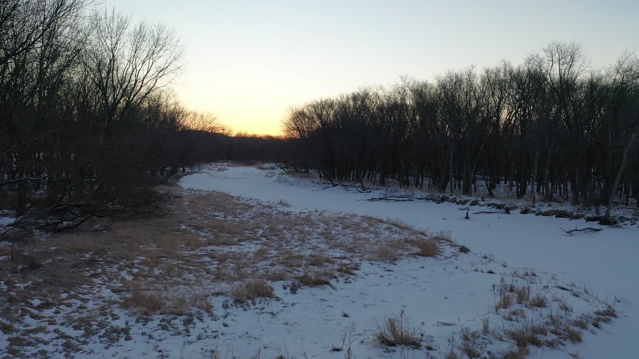 amanecer o atardecer de invierno sobre el río y el bosque congelados