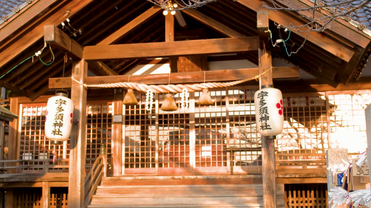 緩慢向上搖攝，展現金澤一座神道教神社精緻的木雕細節和燈籠。