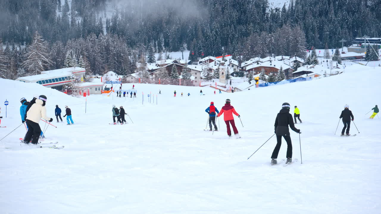 Multiple people skiing on the mountains at a ski resort in dolomites, italy